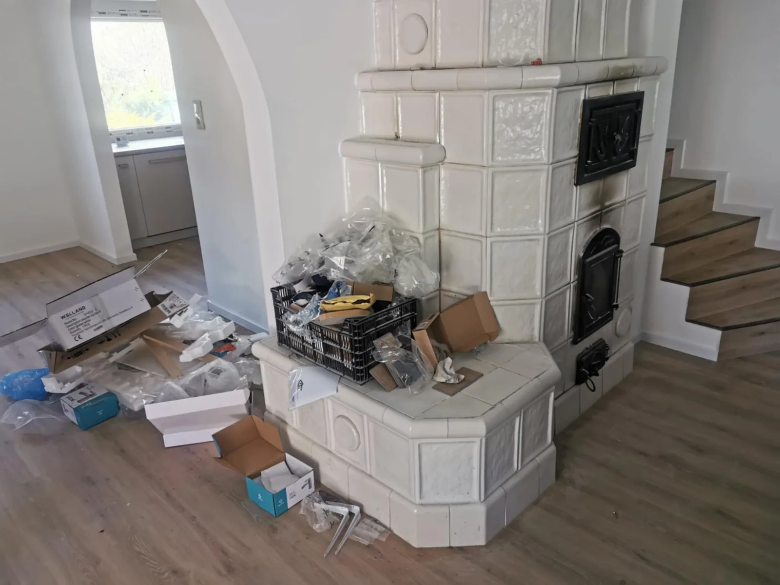 Nappali a takarítás előtt, csomagolóanyagokkal a kandalló körül